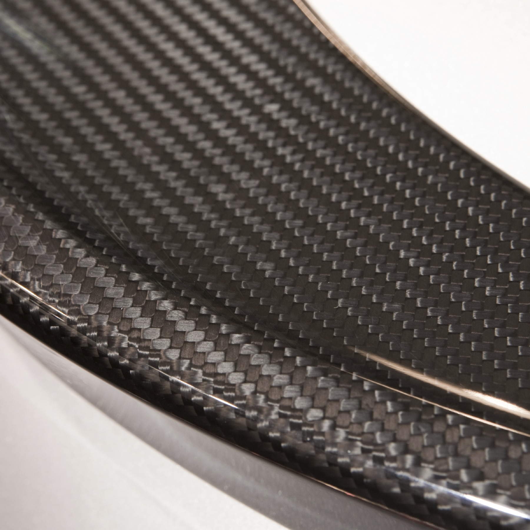 Detail of a carbon fiber molded element, with close up of the textured surface and pattern of the high technology material.